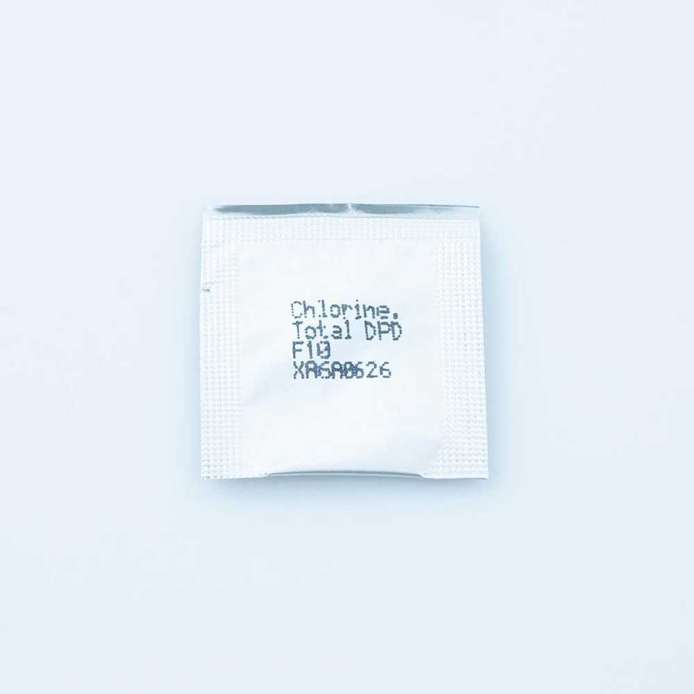 A single Chlorine Total DPD F10 reagent sachet in a silver foil packet, printed with the product name, lot code, and expiration details.