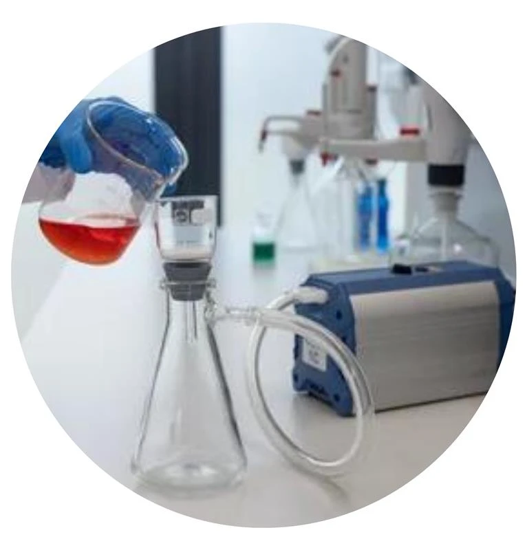 Laboratory vacuum filtration setup with a conical flask, vacuum pump, and a gloved hand pouring red liquid into a filter funnel.